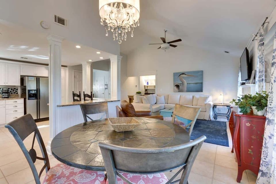 Your open-concept living space flows beautifully from dining to kitchen, with elegant crystal chandelier lighting and comfortable seating for memorable meals.