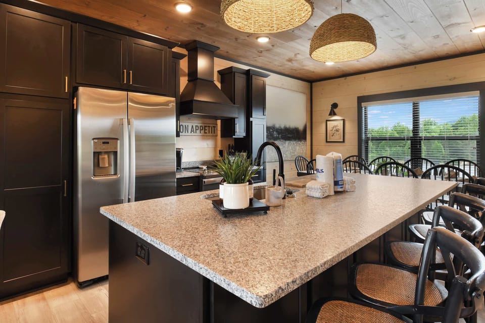 Modern kitchen with a large granite island and seating for eight.