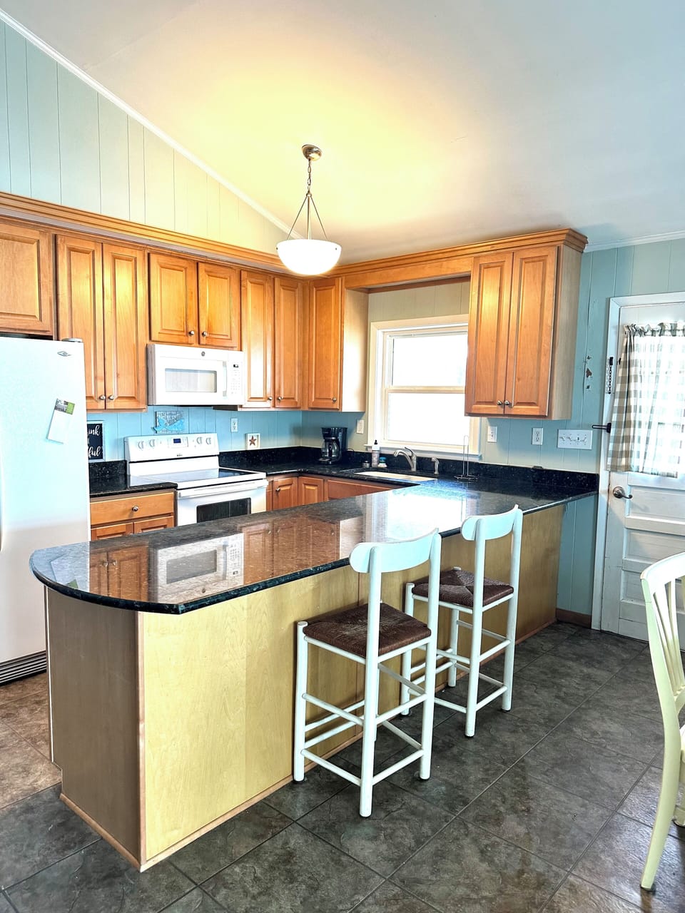 Kitchen looks into living room and through windows for a perfect beach view.