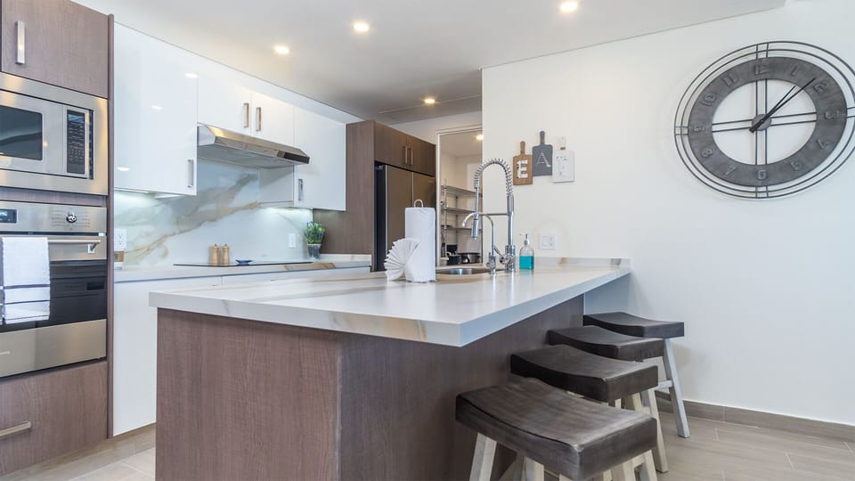 the complete kitchen with stools and lots of counter top space