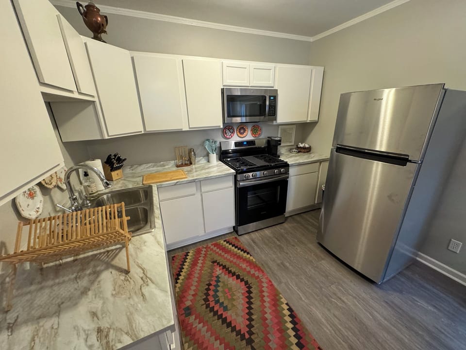 Kitchen with gas stove, full refrigerator, dishes, cookware, Kuerig/French press