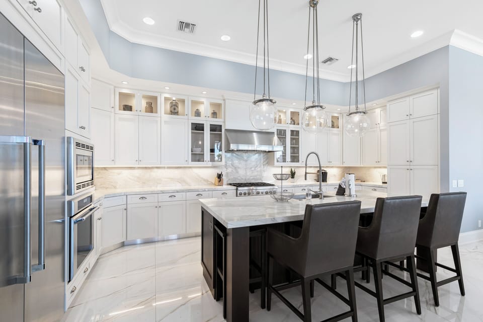 Custom white kitchen cabinets pop against pale blue walls.