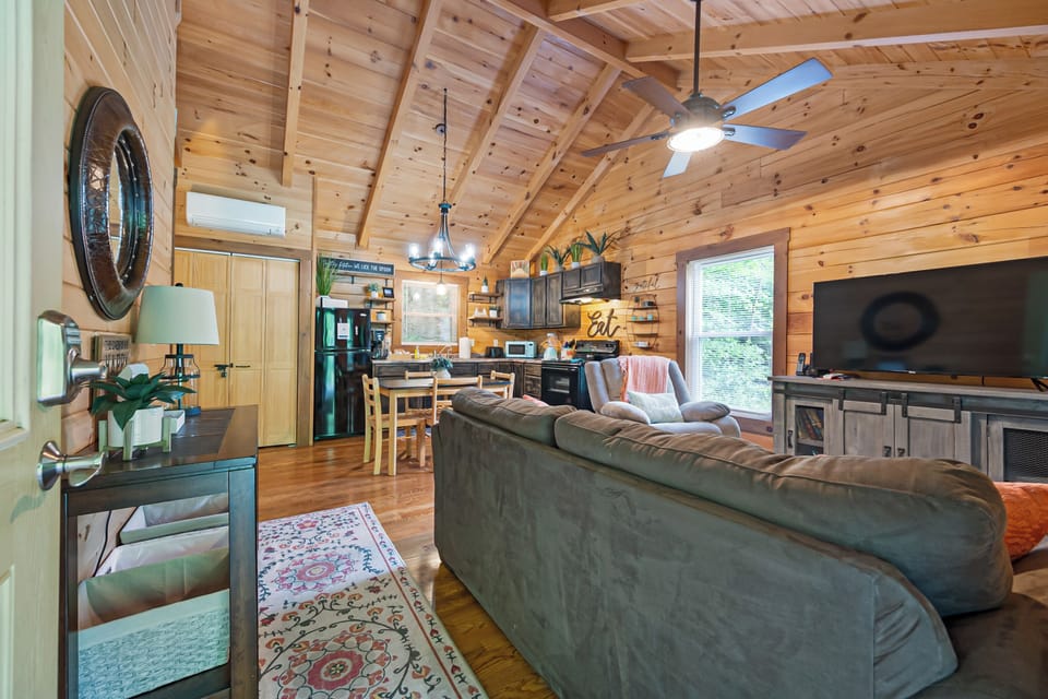Warm, open-concept living area with vaulted ceilings, comfy seating, and rustic charm.