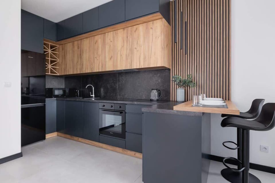 A stylish open-plan living area with sleek kitchen cabinetry, integrated appliances, and a central island.