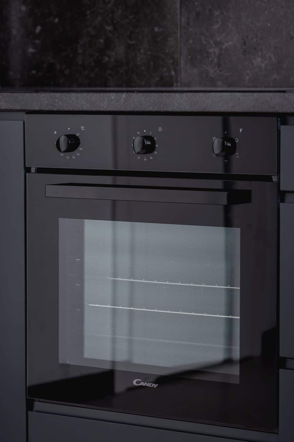 A close-up of a built-in oven in matte black finish, seamlessly integrated into the cabinetry.
