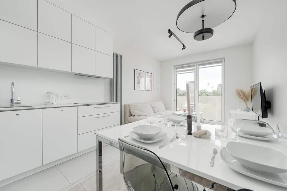 Kitchenette featuring white cabinets, with a dining area that includes a table and chairs.