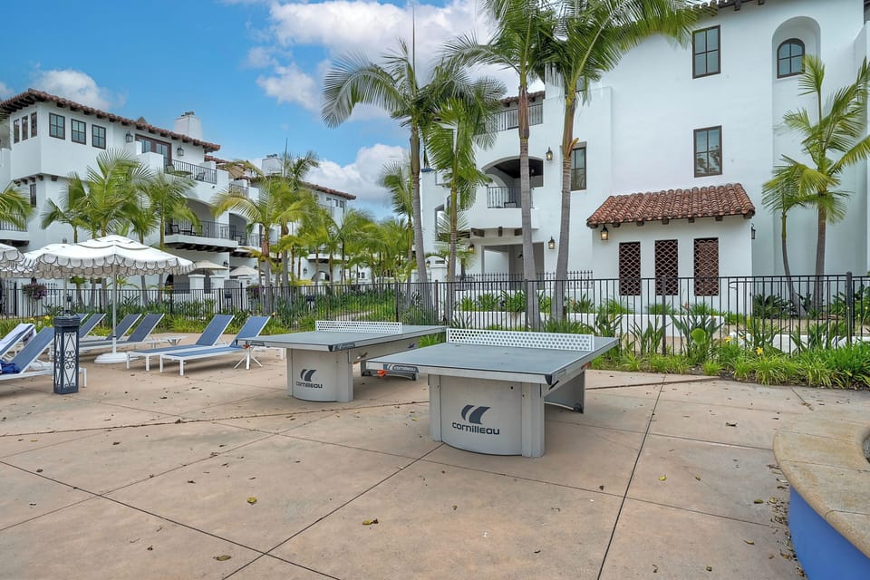 Outdoor relaxation meets entertainment with ping pong tables, lounge chairs, and lush tropical surroundings.