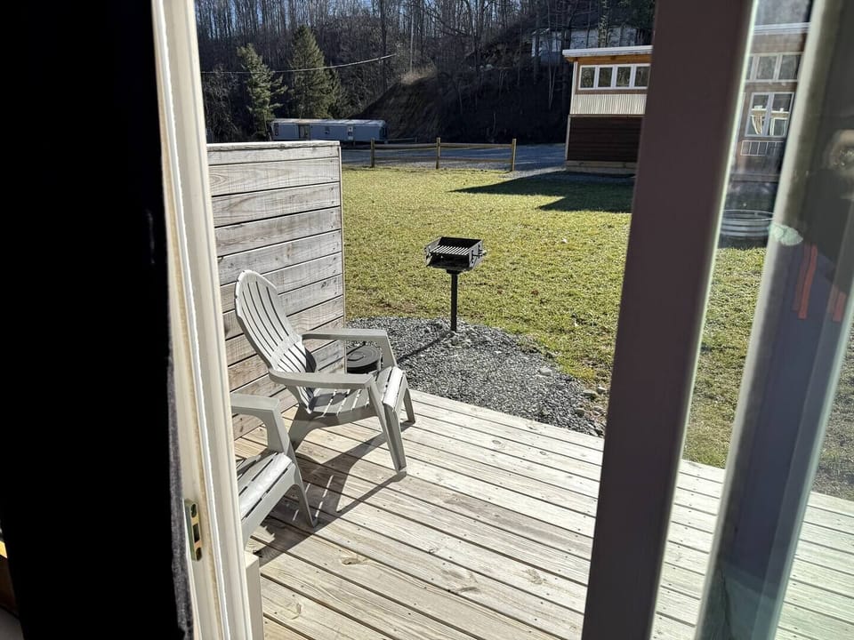 Back porch off living area with charcoal grill shared with neighboring unit.