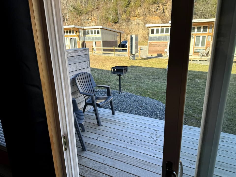 Back porch off living area with charcoal grill shared with neighboring unit.