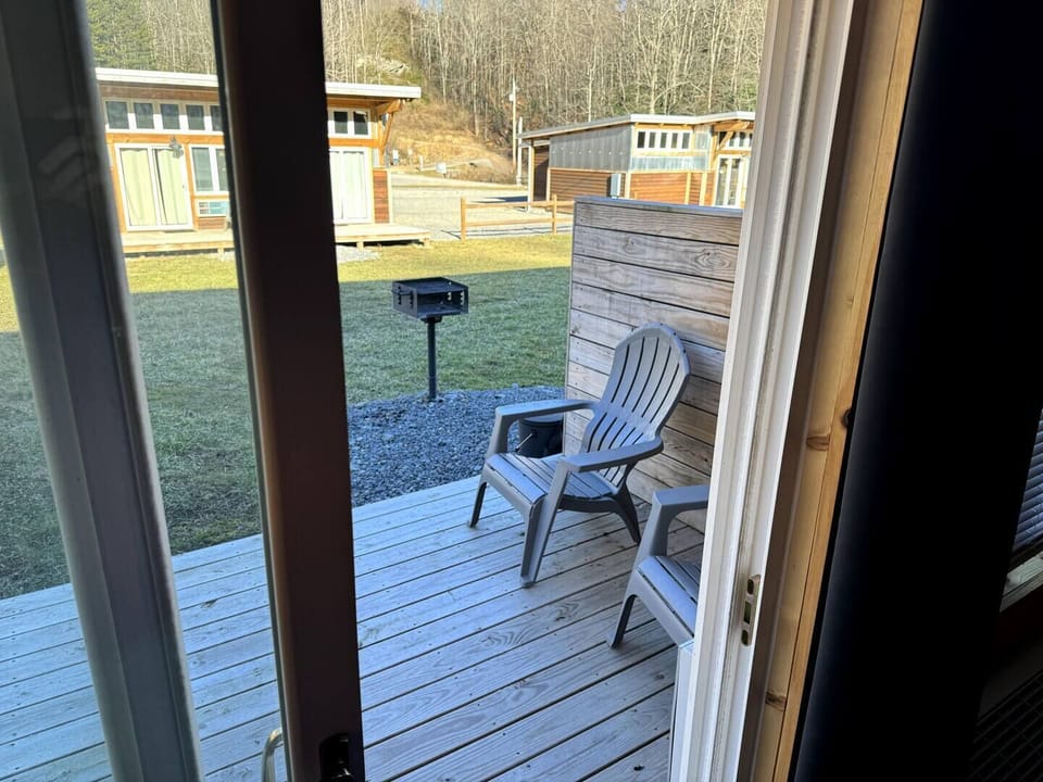 Back porch off living area with charcoal grill shared with neighboring unit.