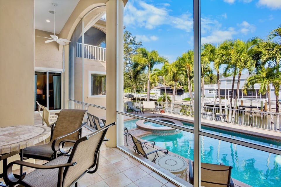 Screened-in lanai with dining area overlooking the pool