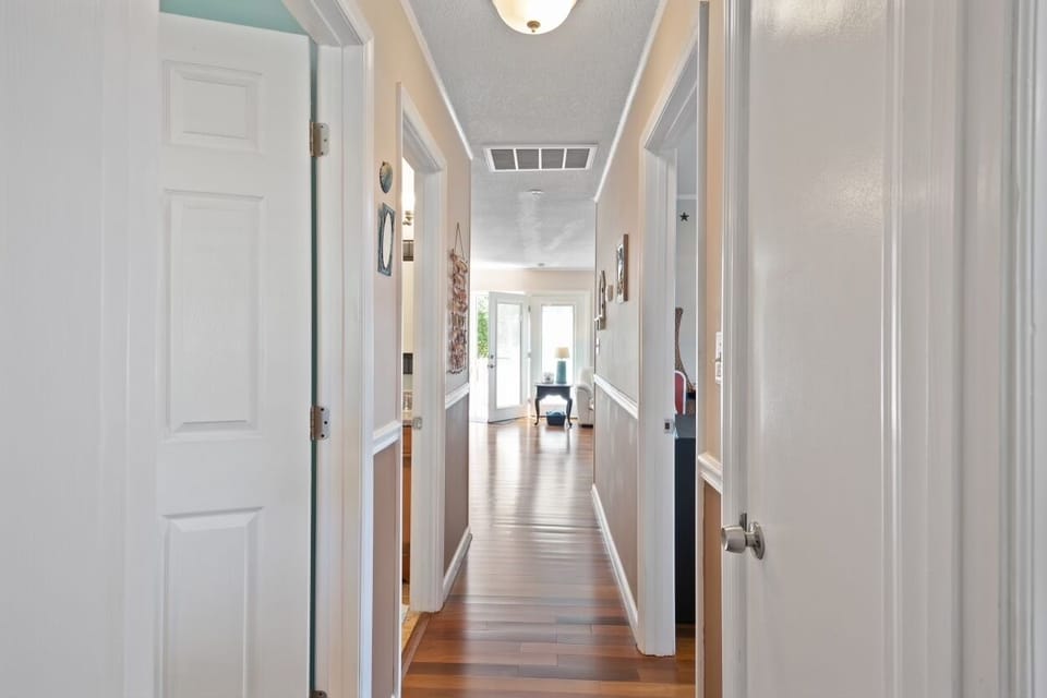View down the hallway from the back bedroom towards the living room/kitchen area