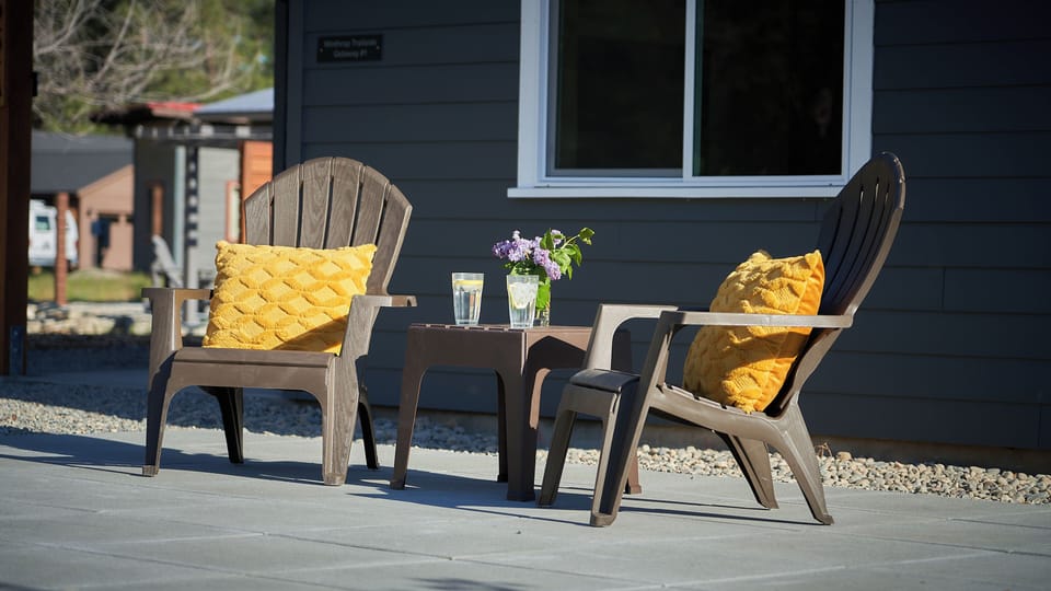 Private patio with adirondack chairs and table.