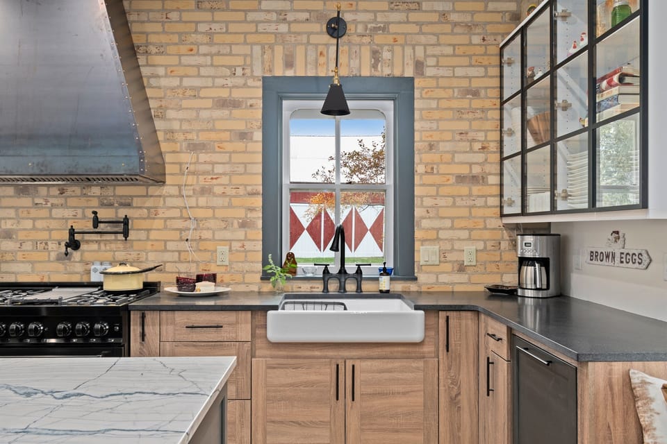 Farmhouse sink perfectly positioned beneath a sunny window view.