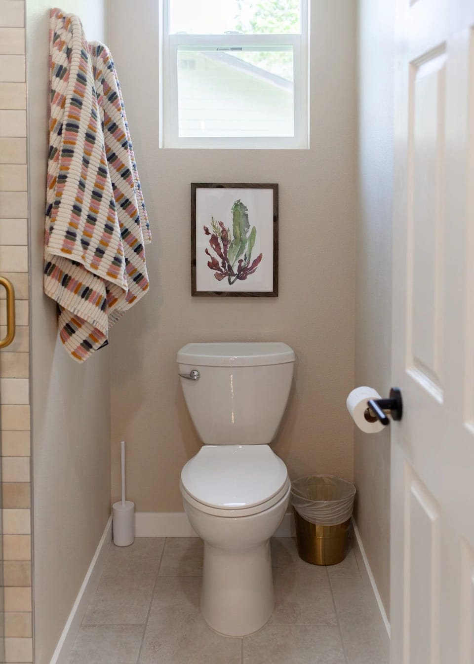 Bright toilet area with natural light and simple wall décor.
