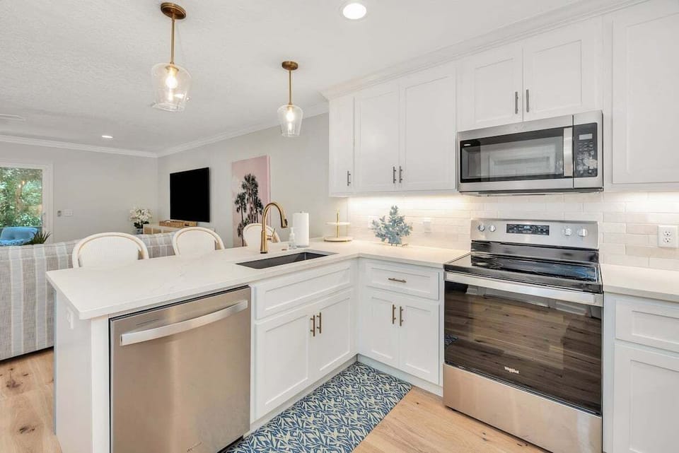 White kitchen with stainless appliances and quartz counters