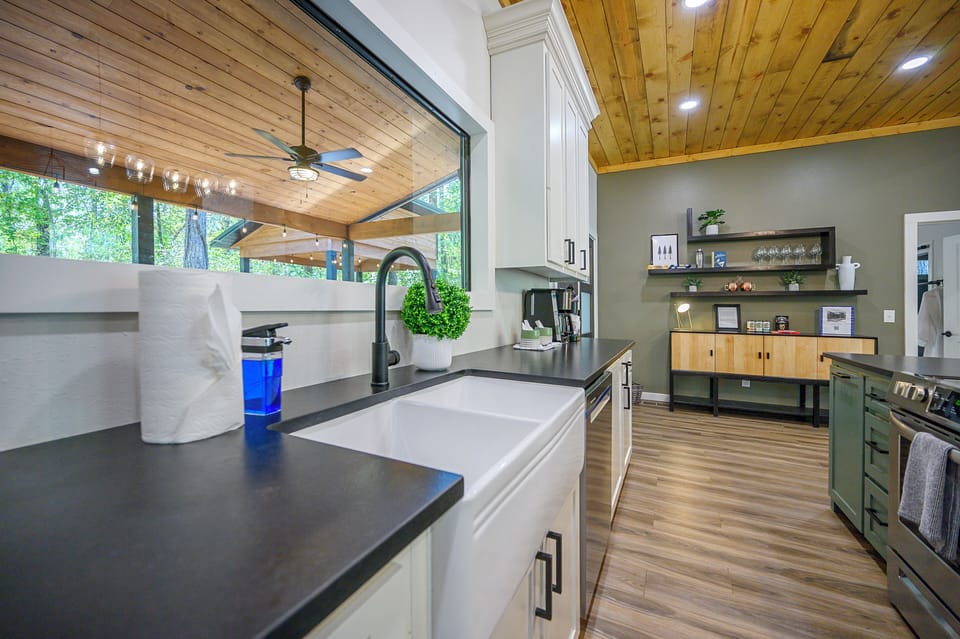 The kitchen features a gorgeous farmhouse sink overlooking the back patio.