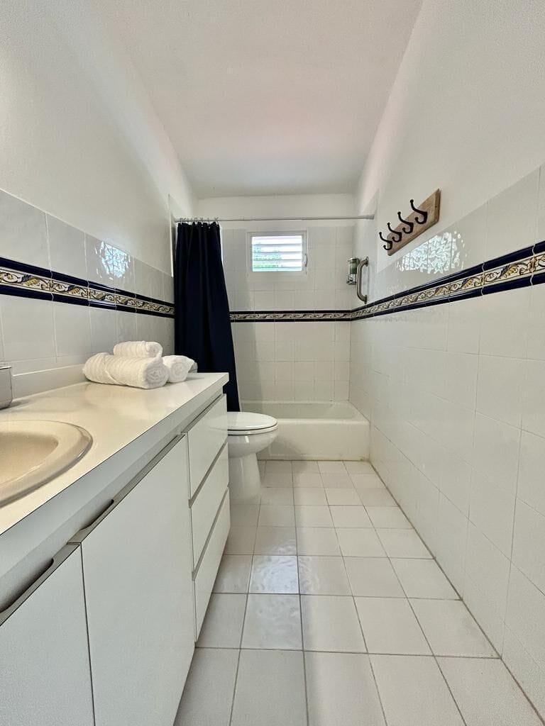 A serene and spotless bathroom that perfectly combines simplicity and comfort, making every shower a tranquil escape.