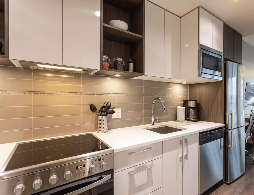 Kitchen setup complete with modern stainless steel appliances, electric range, and built-in microwave.