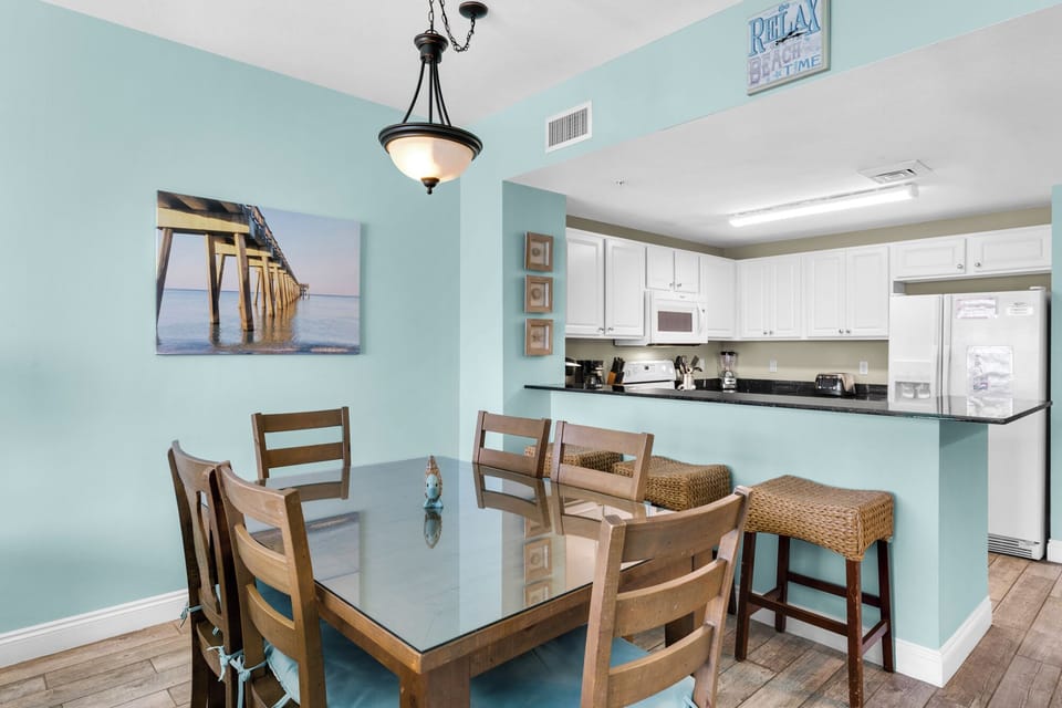 Dining Area - A bright, stylish dining area for six ideal for enjoying fresh meals and good conversation with the beach as your dining companion. Includes 3 bar stools for extra seating.