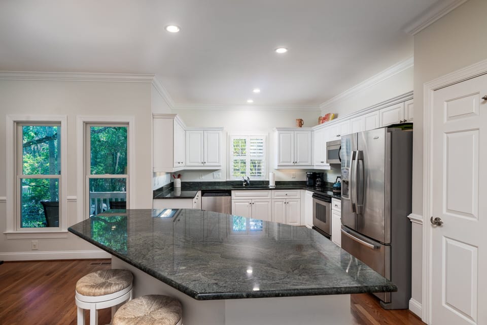 A large island in the kitchen with 2 stools