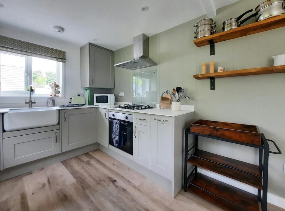 Fitted kitchen with built-in elective oven and gas hob, microwave and toaster