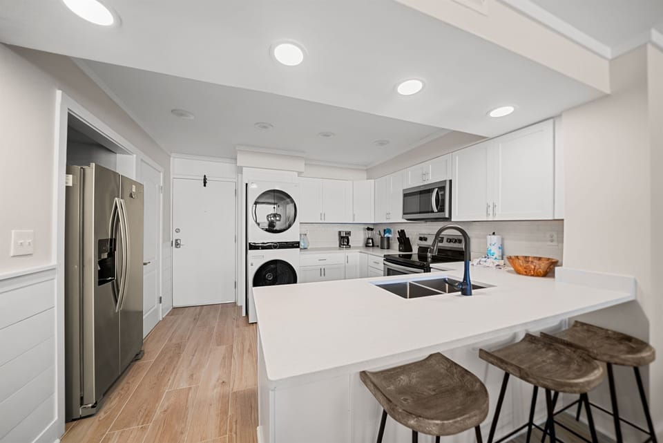 Your fully equipped modern kitchen awaits with gleaming countertops, stainless steel appliances, and a breakfast bar for morning coffee.