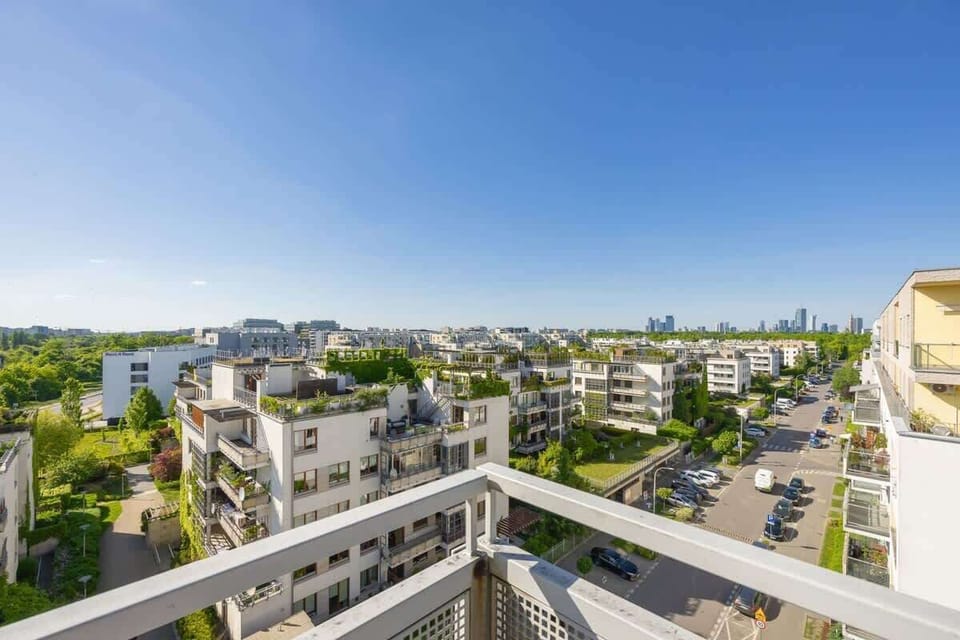 A clearer balcony perspective with blue skies and cozy outdoor furniture.

