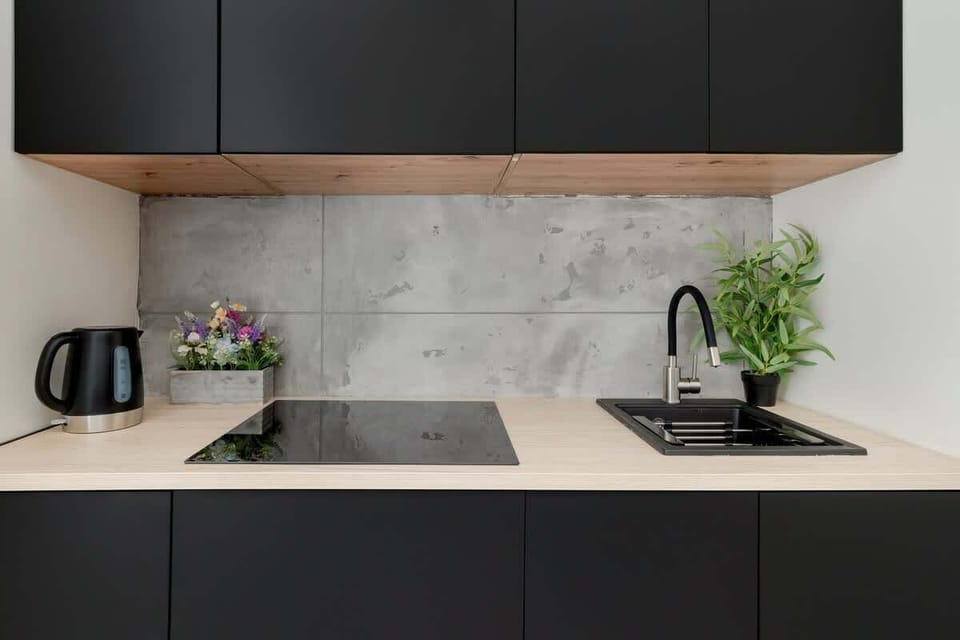A modern black and white kitchen area with sleek cabinetry and built-in appliances.


