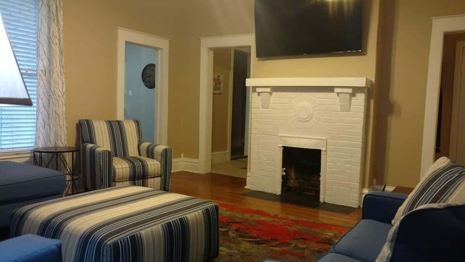 Living Room with large flat screen Smart TV and free WiFi ! New modern and very comfortable sectional couch with chaise & large ottoman plus a matching loveseat & chair decorated with metal art, a very colorful area rug and a decorative fireplace!