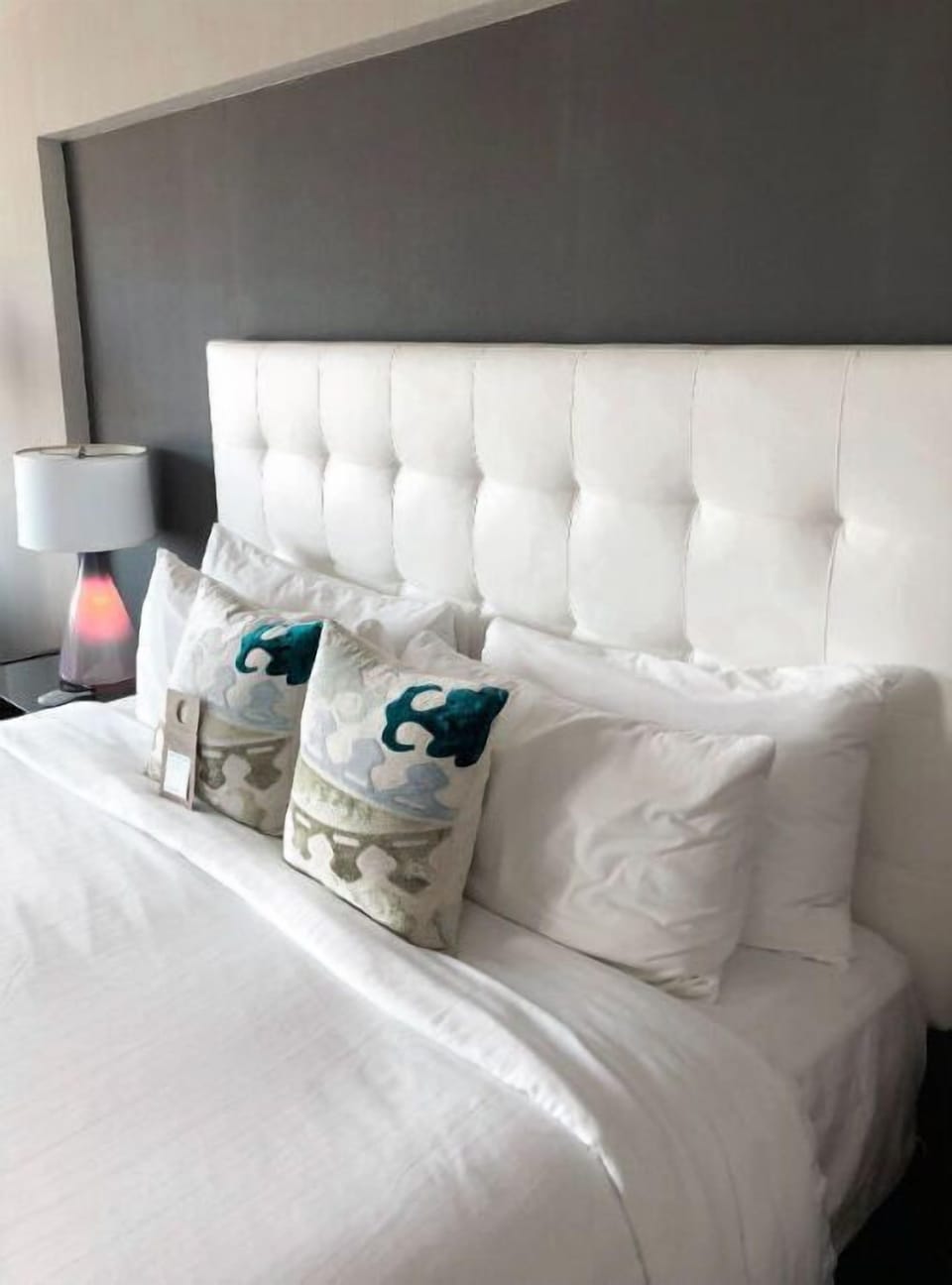 Luxuriously styled bedroom with a plush, tufted headboard and soothing color scheme, creating a sanctuary for rest and relaxation.