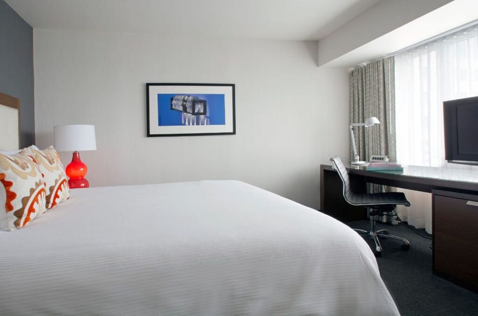 Unwind in this serene, minimalist bedroom with plush bedding and a tranquil atmosphere, designed to ensure a restorative night's sleep.