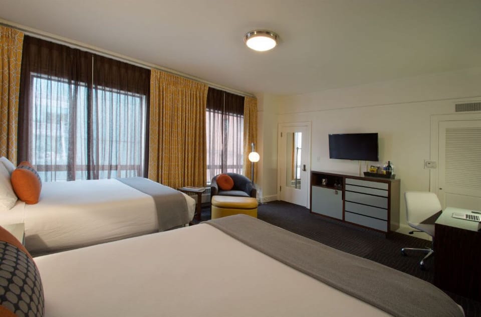 Spacious Double Bed room with ample natural light, featuring comfortable seating and a practical work area.
