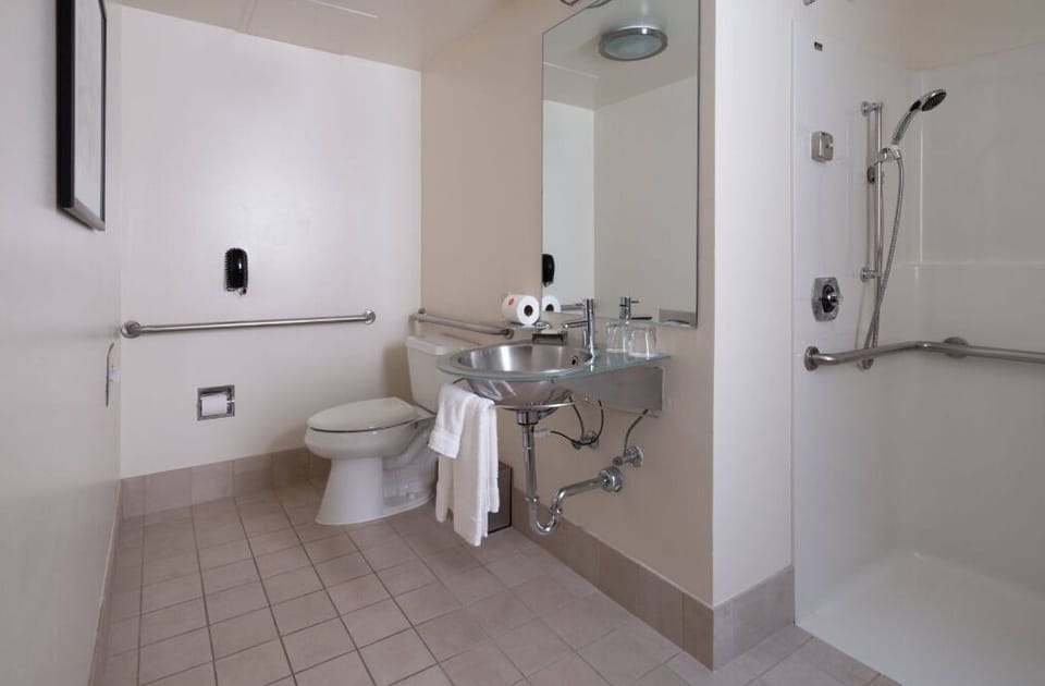 Accessible and spacious ADA-compliant bathroom designed for comfort and safety, featuring grab bars and ample room for mobility.