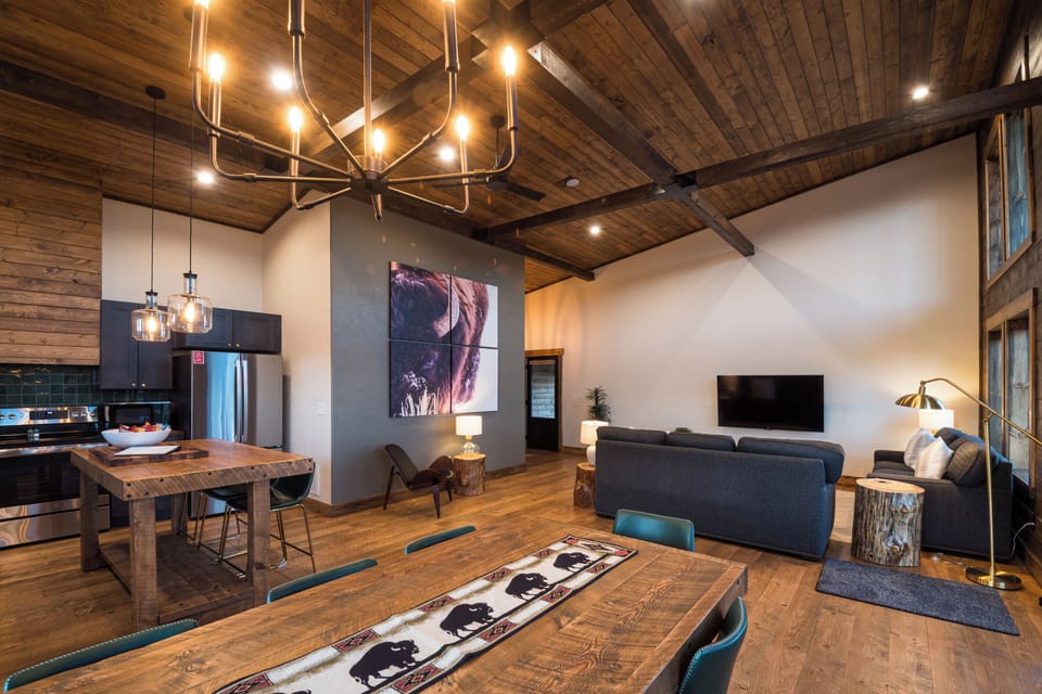 The open layout connects the kitchen, dining table, reading nook, and great room, giving your group room to cook, eat, and relax together.