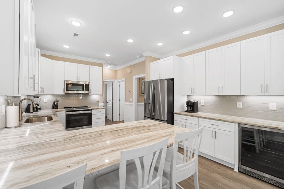 Your gourmet kitchen awaits with gleaming stainless appliances, granite counters, and a spacious island perfect for morning coffee or evening meals together.