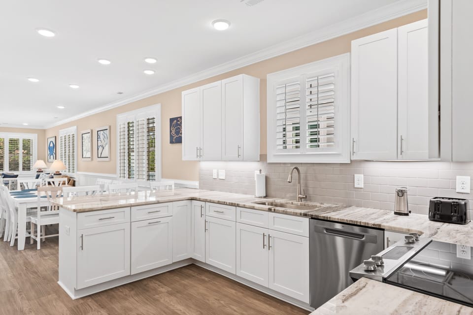 You'll love preparing meals in this bright, modern kitchen with granite counters, stainless appliances, and ample cabinet space for all your culinary needs.