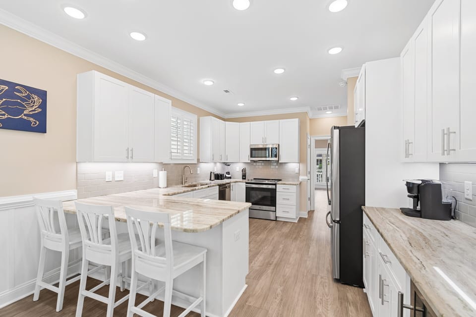 Your fully-equipped kitchen awaits with gleaming countertops, modern appliances, and a breakfast bar where you can sip morning coffee.
