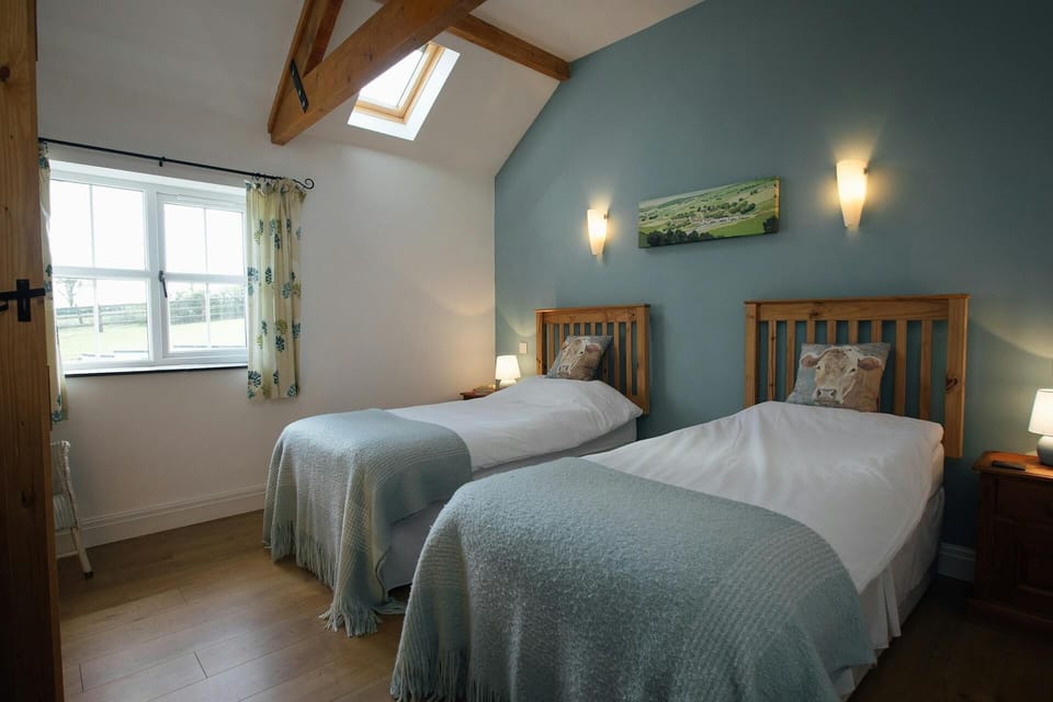 Twin single beds, bedside cabinets with lamps and countryside views from the window