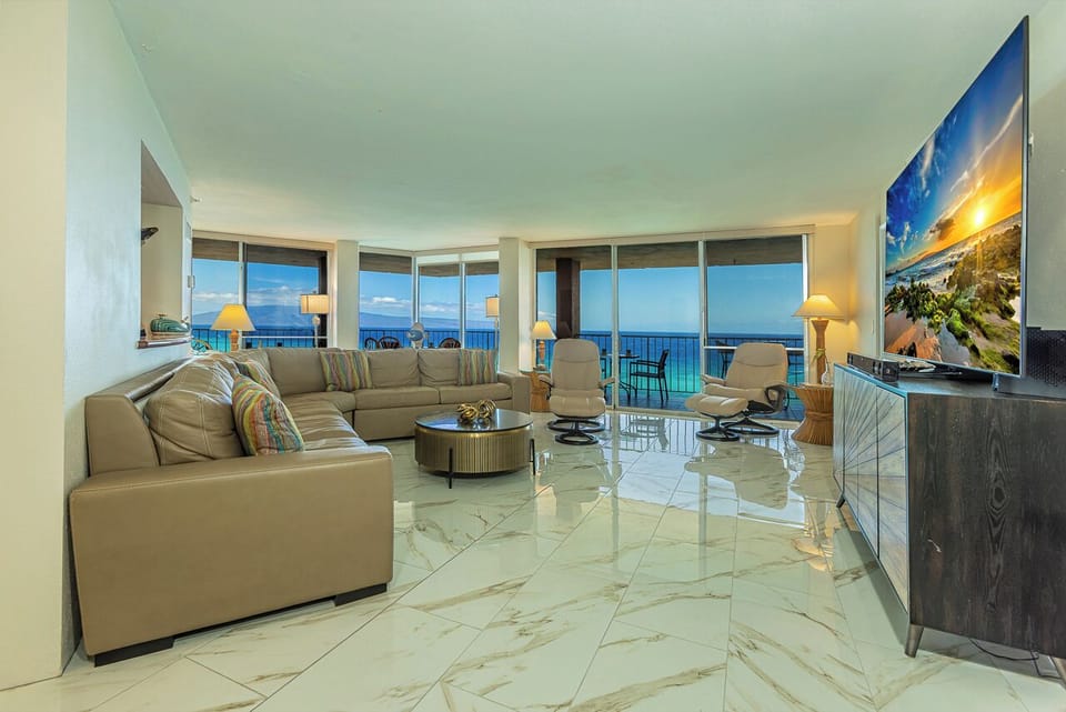The spacious living room offers plush seating, elegant marble floors, and a welcoming ambiance for relaxation.