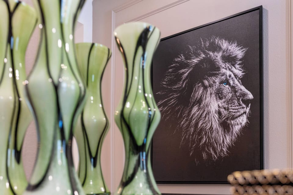Experience a unique artistic touch with soft green glass vases that beautifully enhance the bold black and white lion portrait. This carefully curated decor adds sophistication and intrigue to make your stay even more memorable.