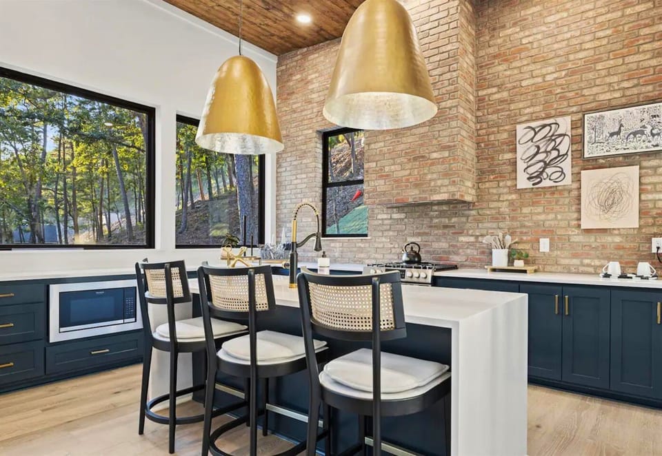 Rise and shine to a wooded view in our sleek kitchen where the great outdoors meets modern comfort. The perfect setting for a tranquil breakfast.