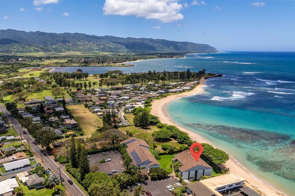 Aerial view of the coastline showcasing calm waters & sandy curves.