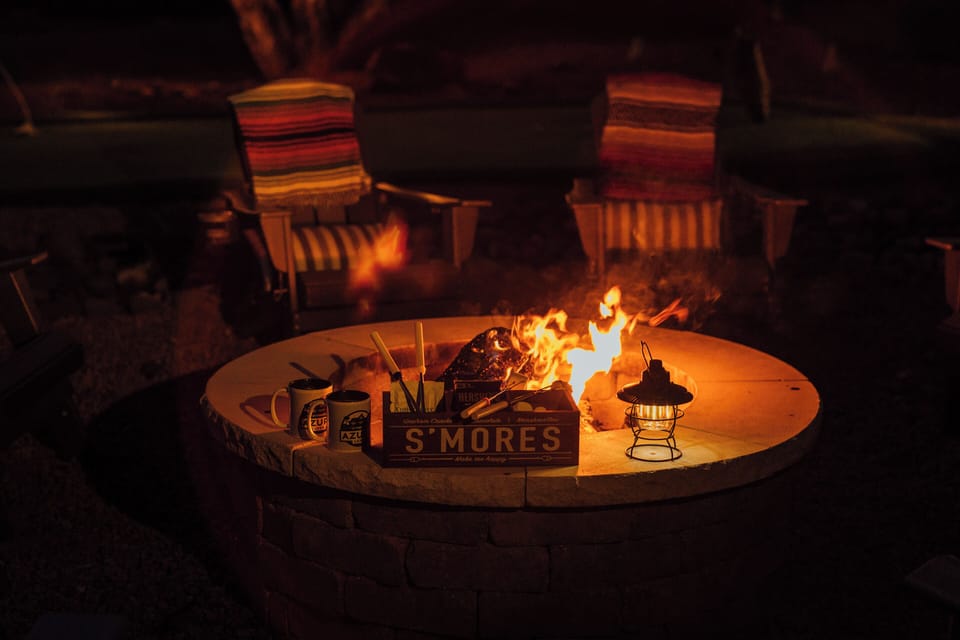 Cozy backyard fire pit with loungers to enjoy s'mores.