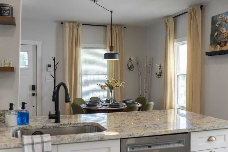 Kitchen island w/ sink & pendant lighting, great for prepping meals or casual chats