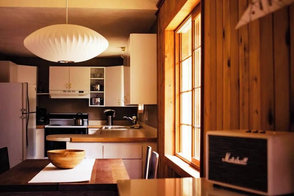Vaulted ceiling and open floor plan. Dining table looks out to boulder hillside.