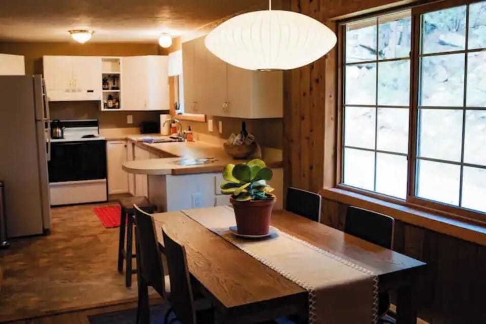 Vaulted ceiling and open floor plan. Dining table looks out to boulder hillside.