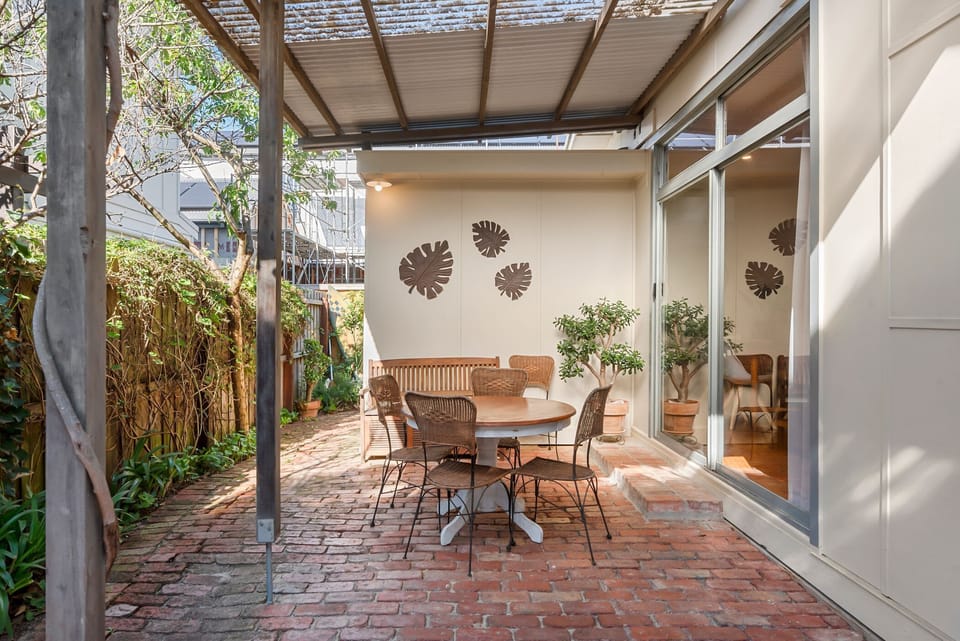 A secondary outdoor area provides a secluded space for morning coffee or sheltered dining