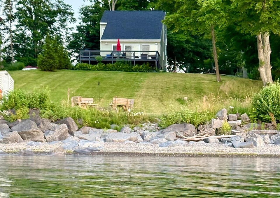 Oak Cottage beach area with a spacious lawn and a firepit. Enjoy easy access to the beach right outside your door!