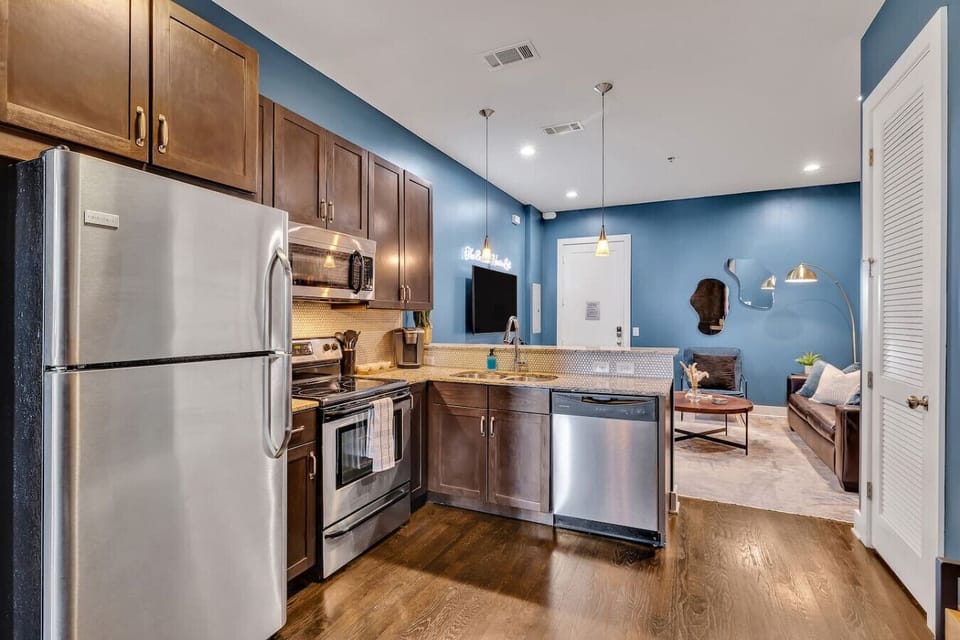 The adjacent kitchen continues the industrial-modern theme, seamlessly integrating into the living area.